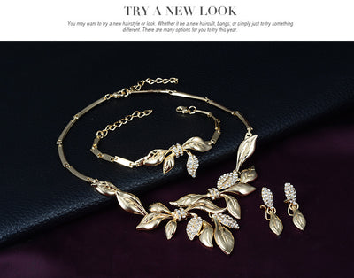 Gold-toned four-piece bridal wedding jewelry set with leaf design and clear rhinestones, including necklace, earrings, bracelet, and ring. - Image 6