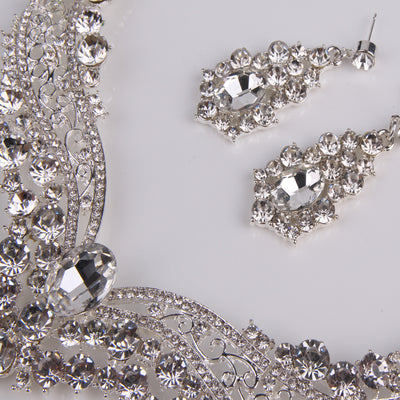 Sparkling silver-tone necklace and matching dangle earrings set, adorned with numerous clear crystals and large oval center stones. - Image 11