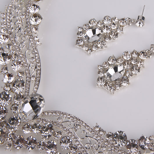 Sparkling silver-tone necklace and matching dangle earrings set, adorned with numerous clear crystals and large oval center stones. - Image 11