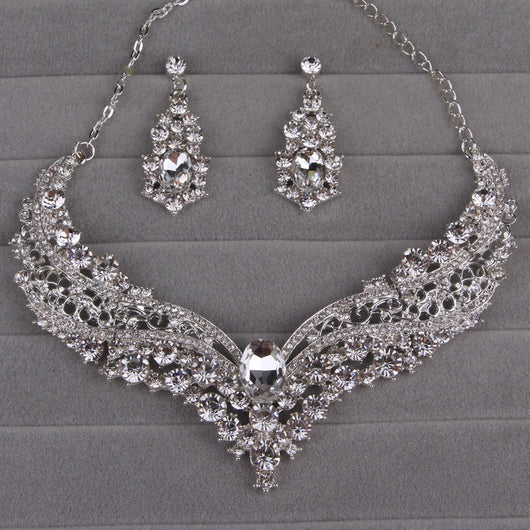 Sparkling silver-tone necklace and matching dangle earrings set, adorned with numerous clear crystals and large oval center stones. - Image 12