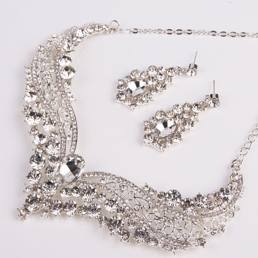 Sparkling silver-tone necklace and matching dangle earrings set, adorned with numerous clear crystals and large oval center stones. - Image 13
