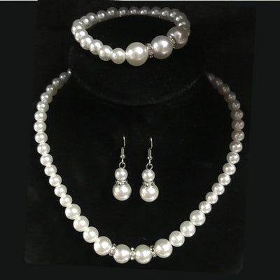 Three-piece white faux pearl jewelry set with rhinestone accents, including a necklace, drop earrings, and a bracelet. - Image 4