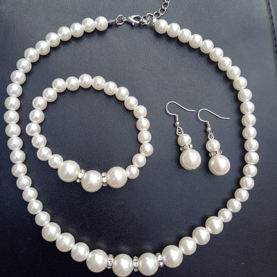 Three-piece white faux pearl jewelry set with rhinestone accents, including a necklace, drop earrings, and a bracelet. - Image 6