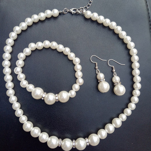 Three-piece white faux pearl jewelry set with rhinestone accents, including a necklace, drop earrings, and a bracelet. - Image 6
