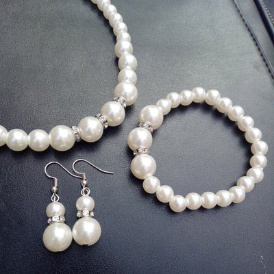 Three-piece white faux pearl jewelry set with rhinestone accents, including a necklace, drop earrings, and a bracelet. - Image 7