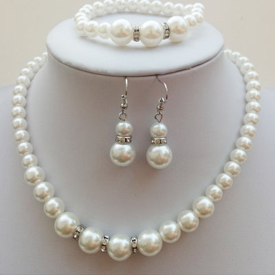 Three-piece white faux pearl jewelry set with rhinestone accents, including a necklace, drop earrings, and a bracelet. - Image 8