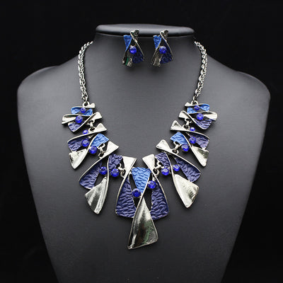 Silver and blue abstract fashion necklace and matching stud earrings set with blue rhinestones on a black mannequin. - Image 8