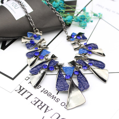 Silver and blue abstract fashion necklace and matching stud earrings set with blue rhinestones on a black mannequin. - Image 13