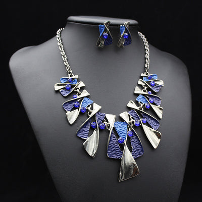 Silver and blue abstract fashion necklace and matching stud earrings set with blue rhinestones on a black mannequin. - Image 16