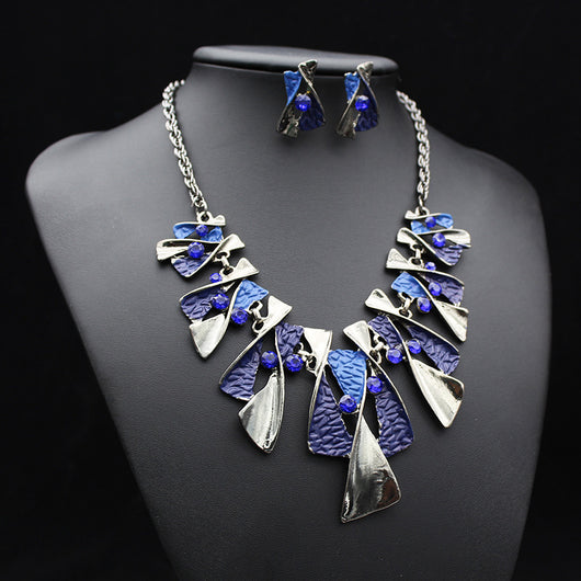 Silver and blue abstract fashion necklace and matching stud earrings set with blue rhinestones on a black mannequin. - Image 16