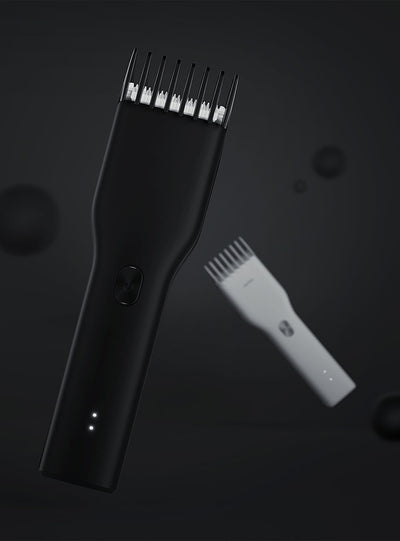 Black cordless hair shaver with a comb attachment and two white indicator lights, with a blurred white shaver in the background. - Image 9