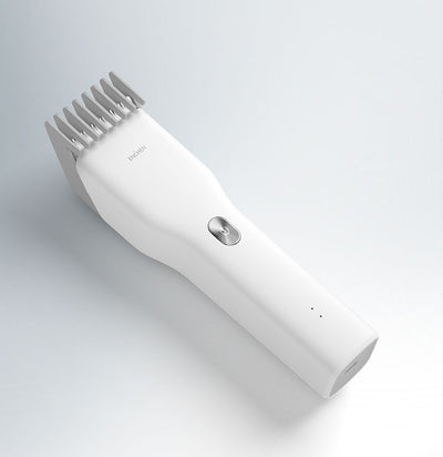 Black cordless hair shaver with a comb attachment and two white indicator lights, with a blurred white shaver in the background. - Image 13