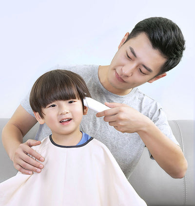 Black cordless hair shaver with a comb attachment and two white indicator lights, with a blurred white shaver in the background. - Image 14