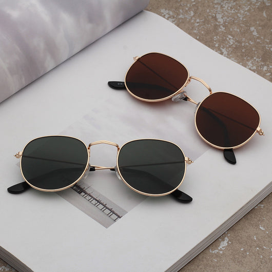 Round metallic sunglasses with iridescent green and gold lenses and a gold-colored metal frame. - Image 17
