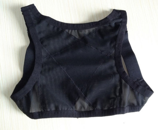 Woman wearing a black posture correction belt with criss-cross back design over a grey shirt, adjusting the strap. - Image 5