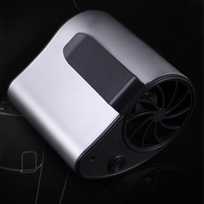 Close-up of a finger pressing the power button on a silver-grey portable waist fan with a black fan grill. - Image 10