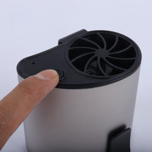 Close-up of a finger pressing the power button on a silver-grey portable waist fan with a black fan grill. - Image 12