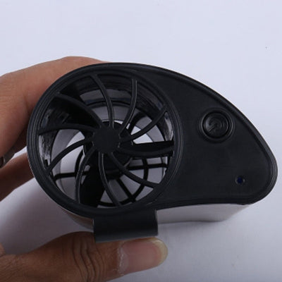 Close-up of a finger pressing the power button on a silver-grey portable waist fan with a black fan grill. - Image 13