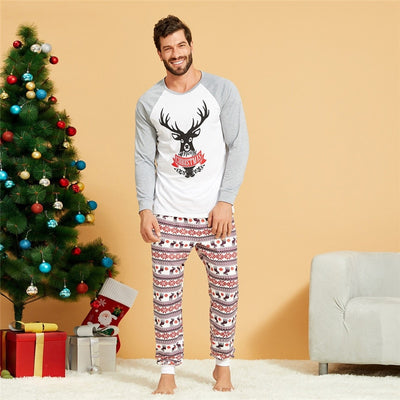 Young boy wearing a Christmas pajama set with a white and grey raglan top featuring a reindeer and fair isle print pants. - Image 13