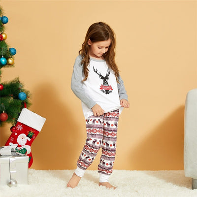 Young boy wearing a Christmas pajama set with a white and grey raglan top featuring a reindeer and fair isle print pants. - Image 16