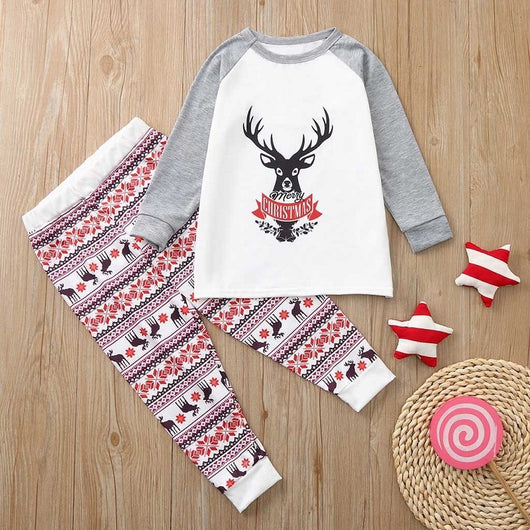Young boy wearing a Christmas pajama set with a white and grey raglan top featuring a reindeer and fair isle print pants. - Image 18