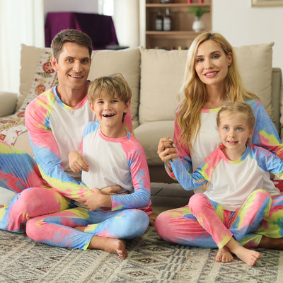 Family of four wearing matching pink, blue, and yellow tie-dye long-sleeved pajama sets in a living room. - Image 9