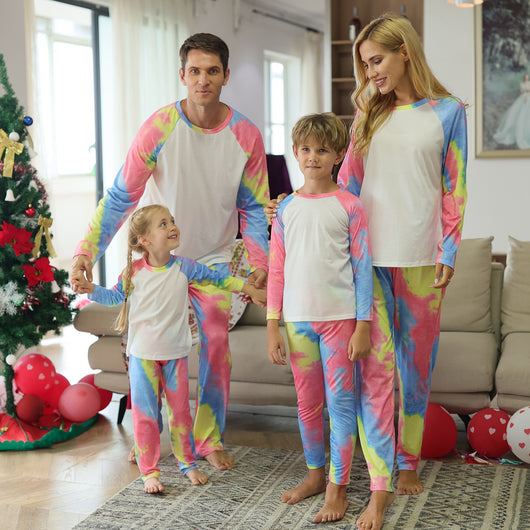 Family of four wearing matching pink, blue, and yellow tie-dye long-sleeved pajama sets in a living room. - Image 12