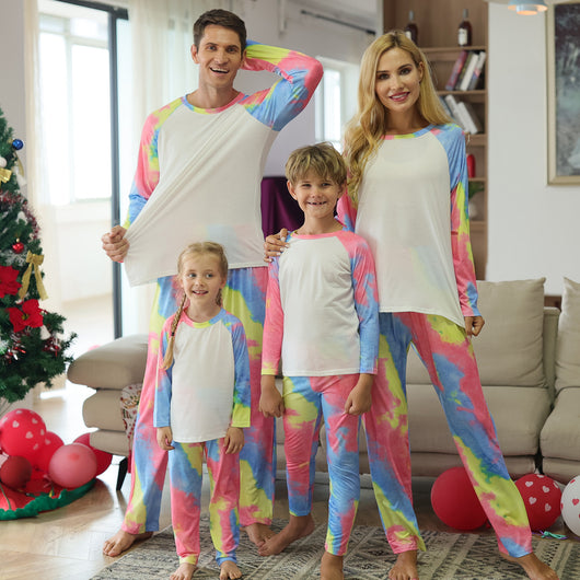 Family of four wearing matching pink, blue, and yellow tie-dye long-sleeved pajama sets in a living room. - Image 13