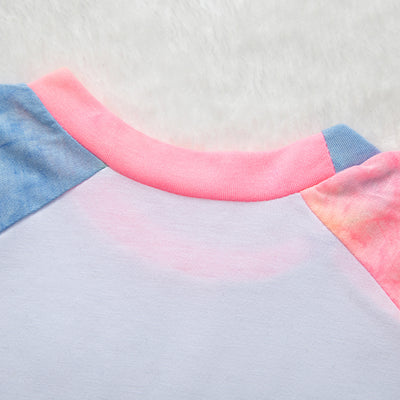 Family of four wearing matching pink, blue, and yellow tie-dye long-sleeved pajama sets in a living room. - Image 19