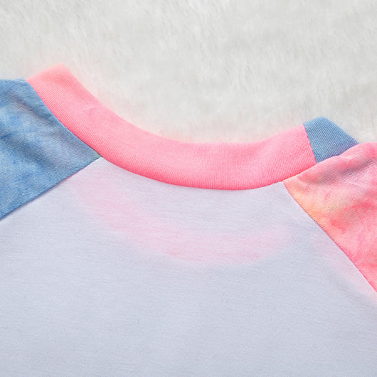 Family of four wearing matching pink, blue, and yellow tie-dye long-sleeved pajama sets in a living room. - Image 19
