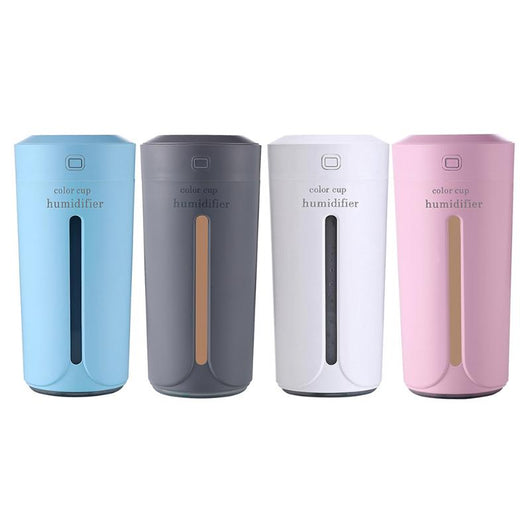 White mini USB ultrasonic humidifier with a green LED light strip, emitting mist, on a white surface. - Image 9