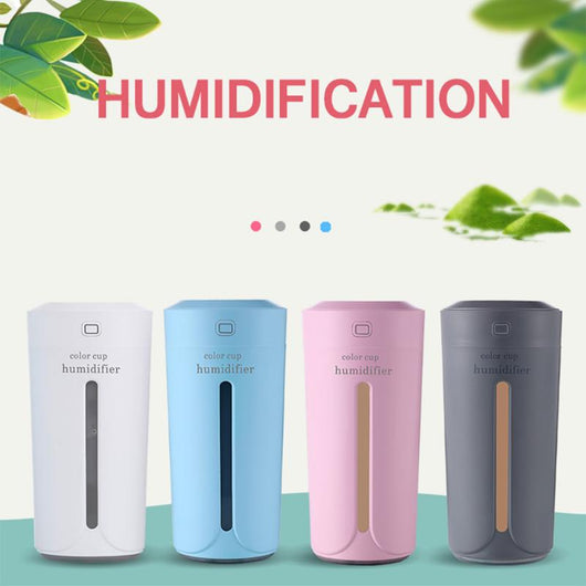 White mini USB ultrasonic humidifier with a green LED light strip, emitting mist, on a white surface. - Image 10