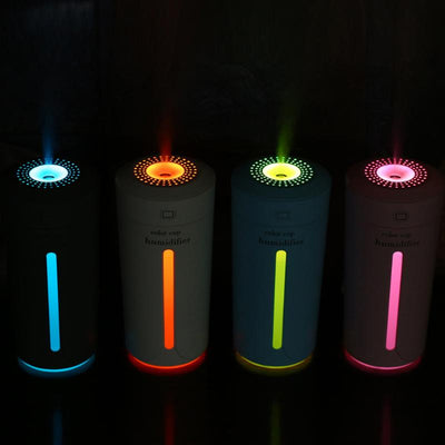 White mini USB ultrasonic humidifier with a green LED light strip, emitting mist, on a white surface. - Image 13