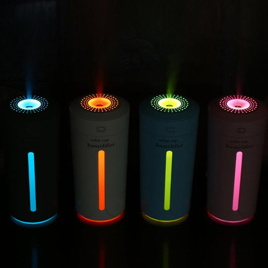 White mini USB ultrasonic humidifier with a green LED light strip, emitting mist, on a white surface. - Image 13