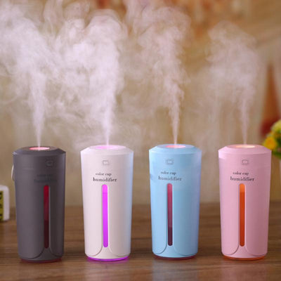 White mini USB ultrasonic humidifier with a green LED light strip, emitting mist, on a white surface. - Image 15