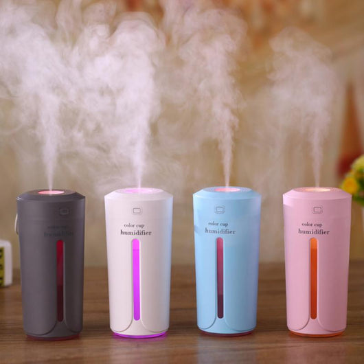 White mini USB ultrasonic humidifier with a green LED light strip, emitting mist, on a white surface. - Image 15