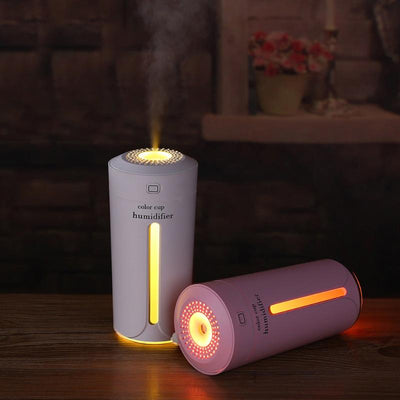 White mini USB ultrasonic humidifier with a green LED light strip, emitting mist, on a white surface. - Image 17