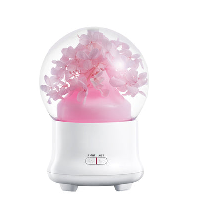 White aromatherapy machine with a clear dome top, featuring blue preserved flowers and an aqua glow. Includes 'LIGHT' and 'MIST' controls. - Image 11