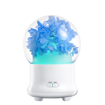 White aromatherapy machine with a clear dome top, featuring blue preserved flowers and an aqua glow. Includes 'LIGHT' and 'MIST' controls. - Image 12