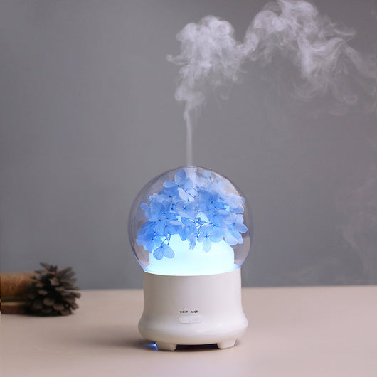 White aromatherapy machine with a clear dome top, featuring blue preserved flowers and an aqua glow. Includes 'LIGHT' and 'MIST' controls. - Image 13