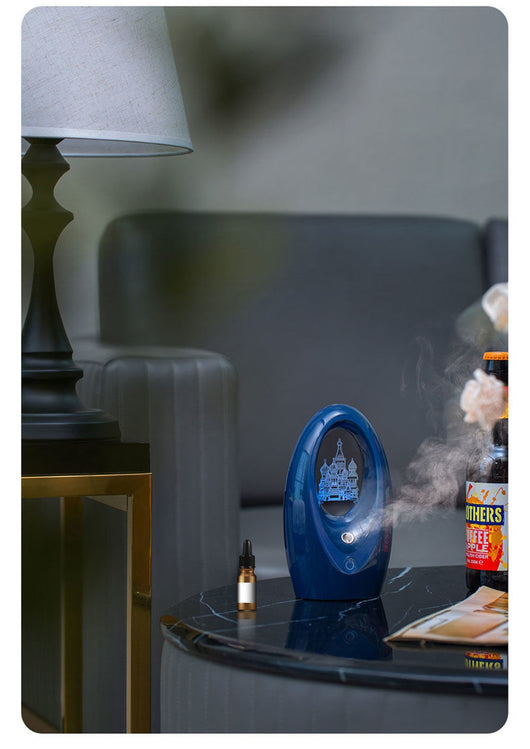 Navy blue USB humidifier with an oval shape and an illuminated castle design in the center. - Image 15