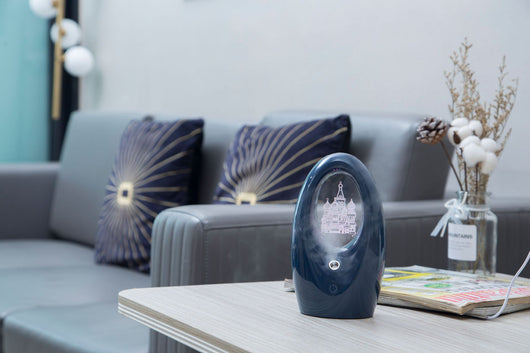 Navy blue USB humidifier with an oval shape and an illuminated castle design in the center. - Image 17