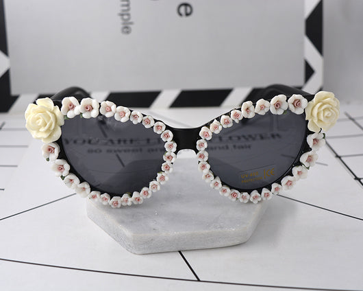 Black cat-eye sunglasses with dark lenses, adorned with small red rose embellishments along the frames. - Image 5