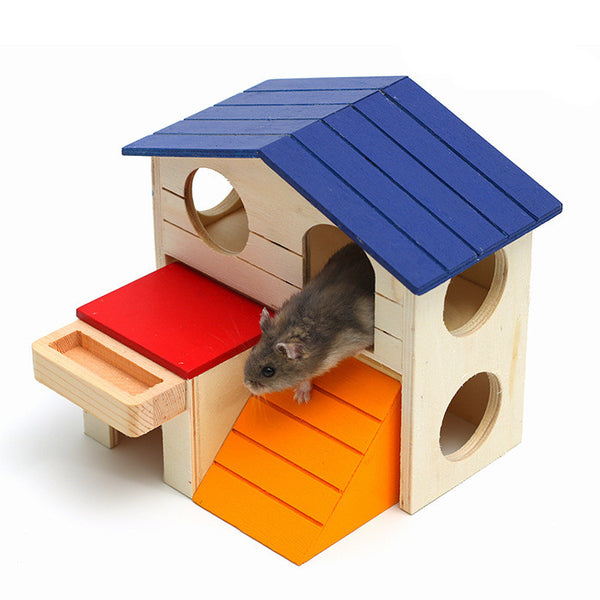 Wooden hamster house with a blue roof, orange ramp, and red platform, featuring a small hamster peeking out.