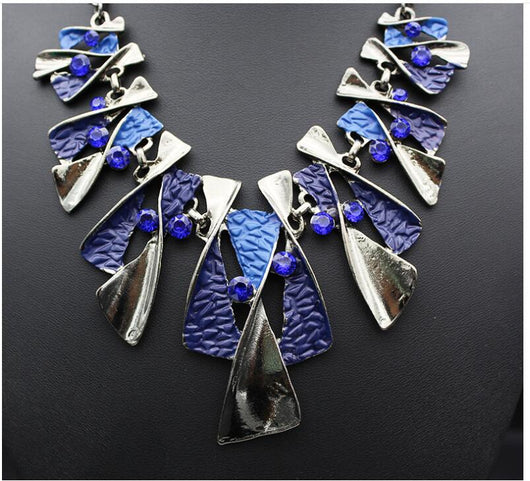 Silver and blue abstract fashion necklace and matching stud earrings set with blue rhinestones on a black mannequin. - Image 4