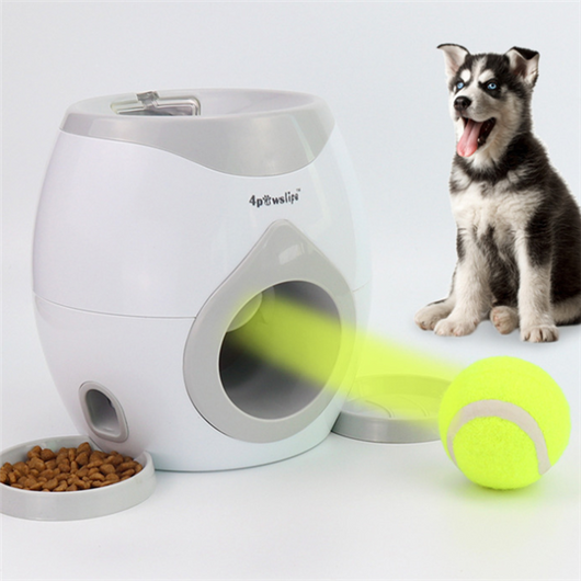 White and grey automatic tennis ball launcher for dogs, dispensing food, with a tennis ball and kibble bowl.