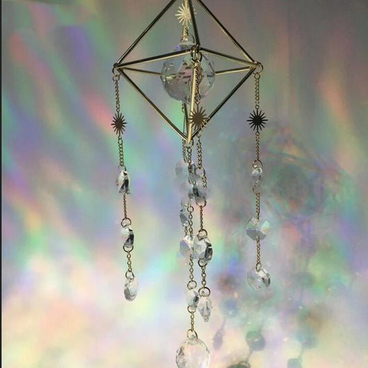 Geometric iridescent suncatcher with a gold frame and dangling crystal pendants, held in a hand, creating rainbow light. - Image 12