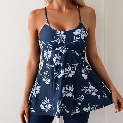 Women's navy blue two-piece swimsuit with white floral tankini top and matching solid swim shorts.