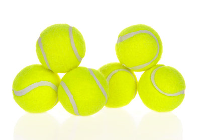 Six bright yellow tennis balls with white seams stacked in a pyramid on a reflective white surface. - Image 18