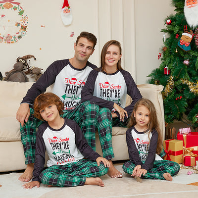 Man wearing a white and black raglan long-sleeve pajama top with a 'Dear Santa They're the Naughty Ones' graphic and green plaid pajama pants. - Image 11